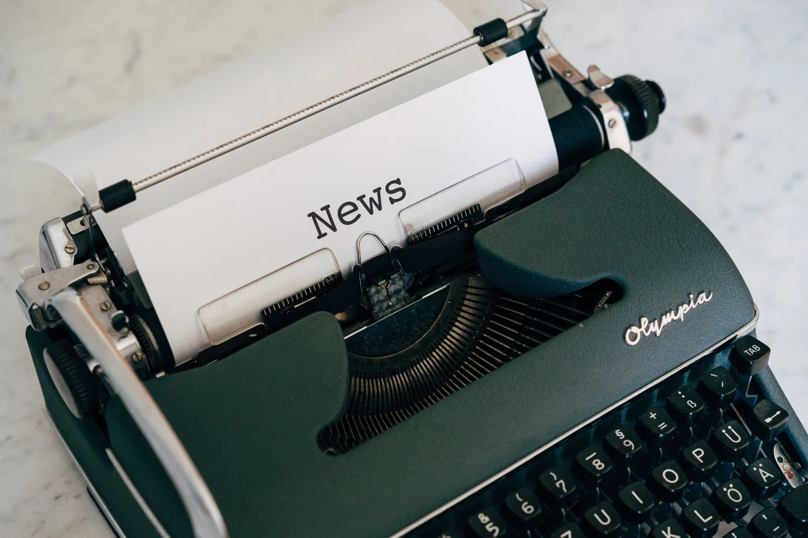 Une machine à écrire vintage avec une feuille sur laquelle est tapé « News »